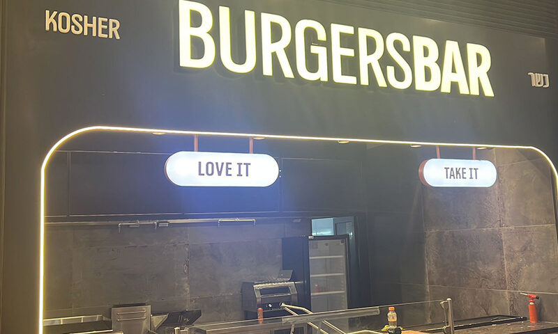 שלט אותיות מוארות BURGRTSBAR על רגע שחור