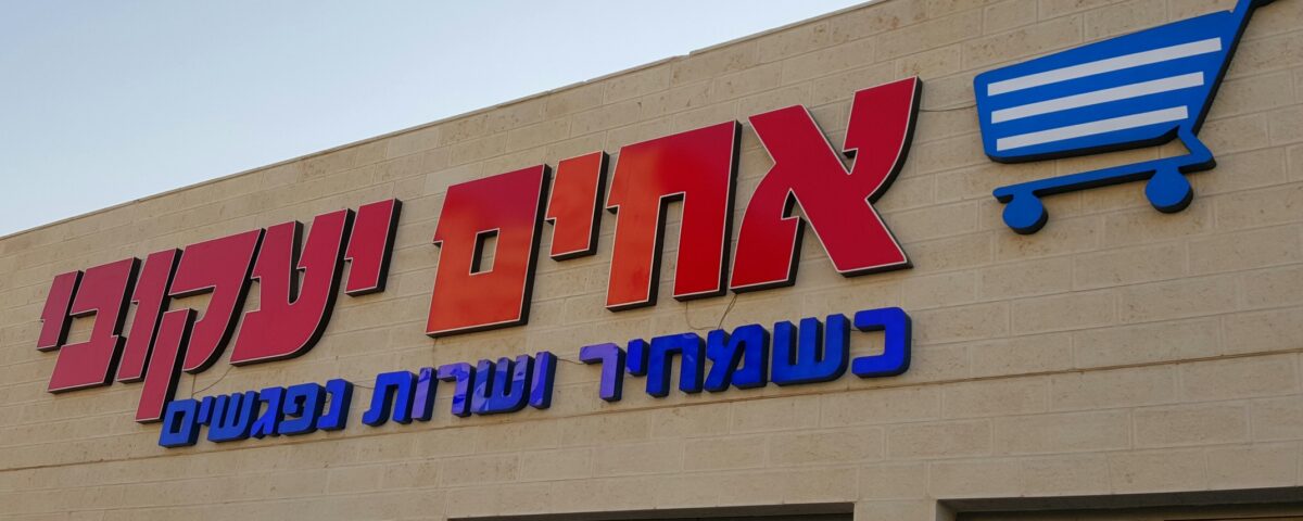 שלט אלומיניום גדול אחים יעקובי בצבע אדום עם כיתוב בצבע כחול מתחת
