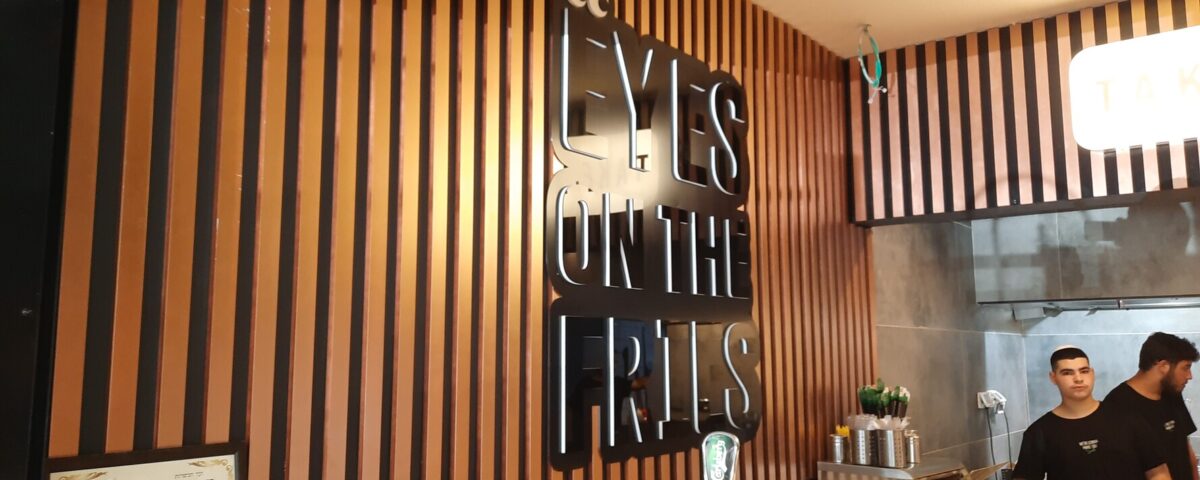 שלט אותיות פנימי שחור על קיר חום